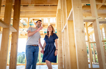 Couple make their dreams of building their own home come true visiting house under construction - obrazy, fototapety, plakaty