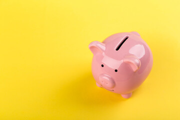 pink piggy bank on a yellow background. Concept of saving money or savings, investment.