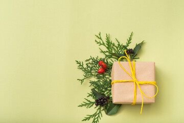 Winter holidays present. Congratulation. Juniper decor. Gift box. Olive green background.