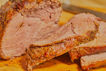 Roast beef joint that has been sliced, resting on a meat board.