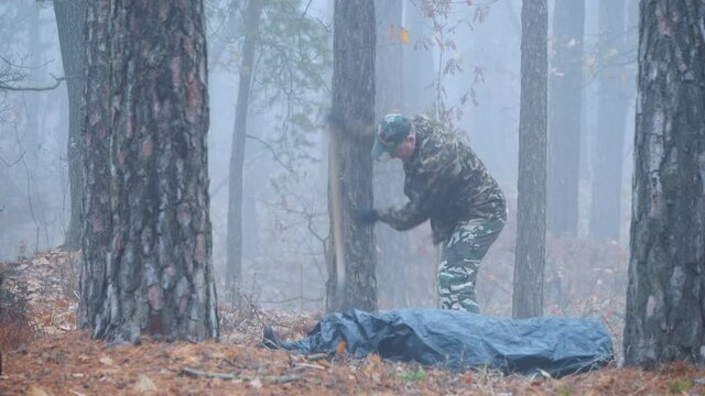 A man burys a corpse in the woods. Scene of the crime concept