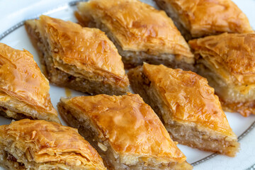 Turkish national delight baklava with walnuts and honey on a white wooden background. Traditional eastern dessert.