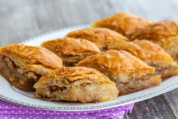 Turkish national delight baklava with walnuts and honey on a white wooden background. Traditional eastern dessert.