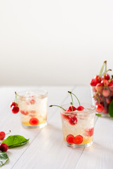 Refreshing summer sweet cherries drink, cocktail with ice and cherry