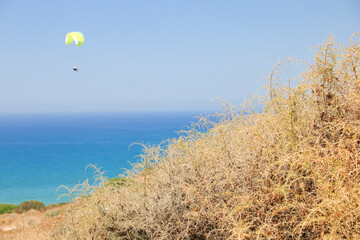 Gelber Paragleiter am blauen Himmel