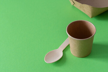 Eco friendly disposable dishes, glass with a spoon and a plate of environmental material