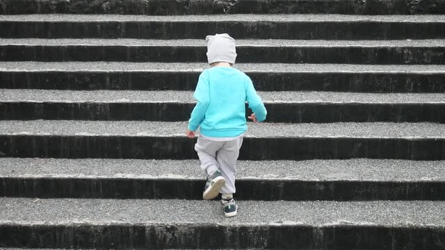 A little boy climbs the steps of the old Temple
