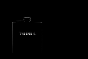 flask for alcohol with the inscription vodka on a black background. Light outline on a black background. copy space.