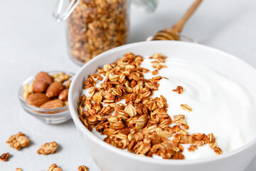 Homemade oatmeal granola bowl with greek yogurt on grey background.