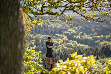 Trail runner stands on a rock in the mountains