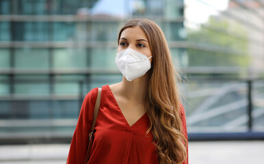 Sense of bewilderment. Young woman in empty city street wearing protective mask. Girl with face...