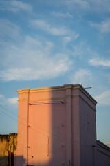 Pink square edifice lit by late sunshine, Merida, Mexico