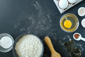 Baking ingredients and baking utensils on a black background. View from above, selective focus, horizontal orientation