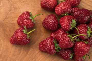 A bunch of strawberries on a wooden board