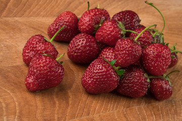 A bunch of strawberries on a wooden board