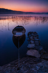 Row boat at still lake in the morning, Sweden.
