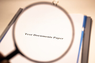 The concept is written on a piece of paper, the words text, documents, papers are written under a magnifying glass. A sheet of paper on plastic folders with documents.