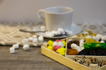 assortment of delicious nuts and dried fruits consisting of plums, peanuts in sesame seeds, dried apricots, candied fruits, kumquat and dates in a wooden package