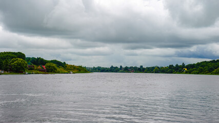Panorama of the green plants and houses side of the river