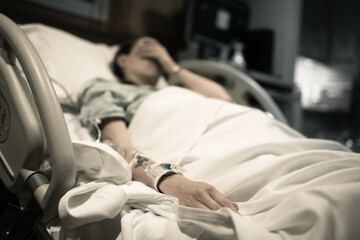 Sick woman lying in hospital bed. 