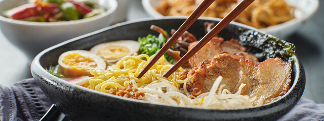 eating japanese tonkotsu ramen with chopsticks