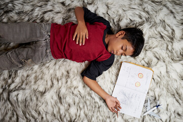 Young student boy fall asleep while study at home