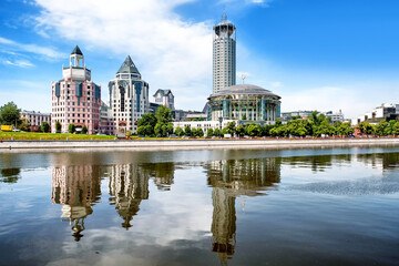 downtown moscow city modern architecture landmark with music hall and office building reflection on moscow river water against scenic blue sky with clouds background. Wide street view