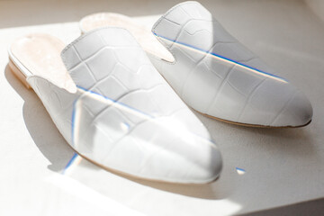 white shoes on a black background in the style for blogging, a finger indicates shoes, a hand...