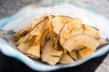 Delicious crispy coconut chips with salted caramel. Natural product made from coconut pulp. Useful snack for a snack. The concept of proper nutrition.