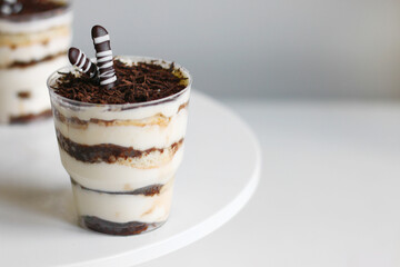 Classic tiramisu in a glass and light background. portioned tiramisu on light background.