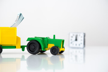 agricultural machinery on a white background. green tractor with a yellow trailer. time to invest in organic food. use as background or for advertising.
