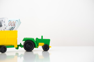 agricultural machinery on a white background. green tractor with a yellow trailer. time to invest in organic food. use as background or for advertising.