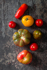 Fresh, ripe multi colored tomatoes on a dark background. Organic food.