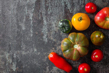 Fresh, ripe multi colored tomatoes on a dark background. Organic food.