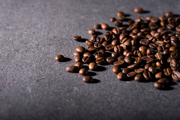 Roasted coffee beans on a stone background. Coffee beans texture. Coffee in beans on dark background. Food background of coffee beans. Abstract background texture. Texture coffee.