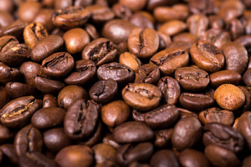 Roasted coffee beans on a stone background. Coffee beans texture. Coffee in beans on dark background. Food background of coffee beans. Abstract background texture. Texture coffee.