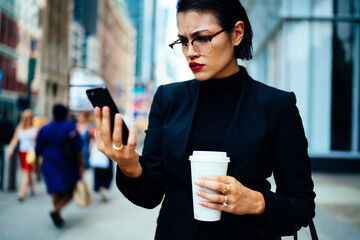 Angry woman trader in optical eyewear reading email with bad news about termination of agreement...