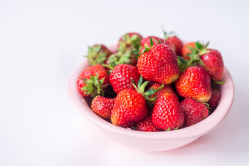 strawberries in a bowl on a white background