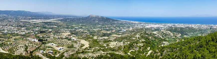 Fototapeta na wymiar Incredible panoramic view from Mount Filerimos. Rhodes Island, Greece. Beautiful scenery at sunny summer day. .Landscape with sea shore and the airport at the horizon
