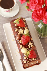 Chocolate cake roll with strawberries, nuts and cheese cream
