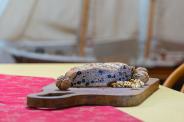 Bizcocho hecho en casa con nueces y otros ingredientes exquisitos, sobre la mesa. Detalle de nueces con y sin cascara.