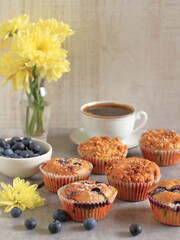 Blueberry muffins on a rustic wooden table and a cup of coffee