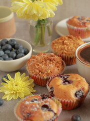 Blueberry muffins on a rustic wooden table and a cup of coffee