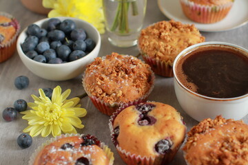 Blueberry muffins on a rustic wooden table and a cup of coffee