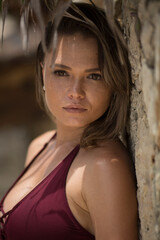 photo of good looking woman in swimsuit pose   on the beach with palm trees  and ocean background