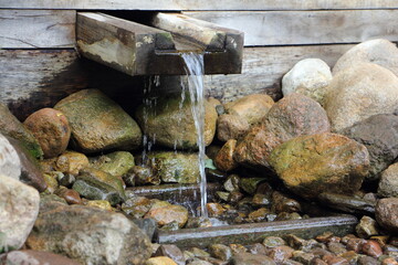 Natural outdoor spring with drinking water in the Park close up on summer day, ecological drink