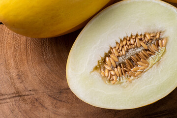 Whole and sliced ​​yellow melon on wooden background