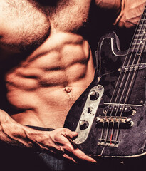 Music concept. Play the guitar. Chest muscles. Electric guitar. Torso man. Instrument on stage and...