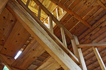 Fototapeta na wymiar Wooden staircase in a new village house in old Russian style, bottom up view