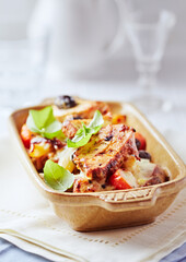 Pork tenderloin baked with Penne pasta, cherry tomatoes, black olives and cheese. Bright background. Close up